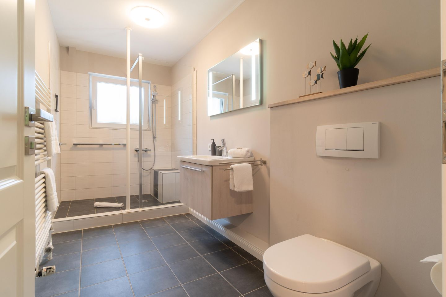 Duschbad mit Glasdusche, Waschtisch mit Spiegel und Wand-WC